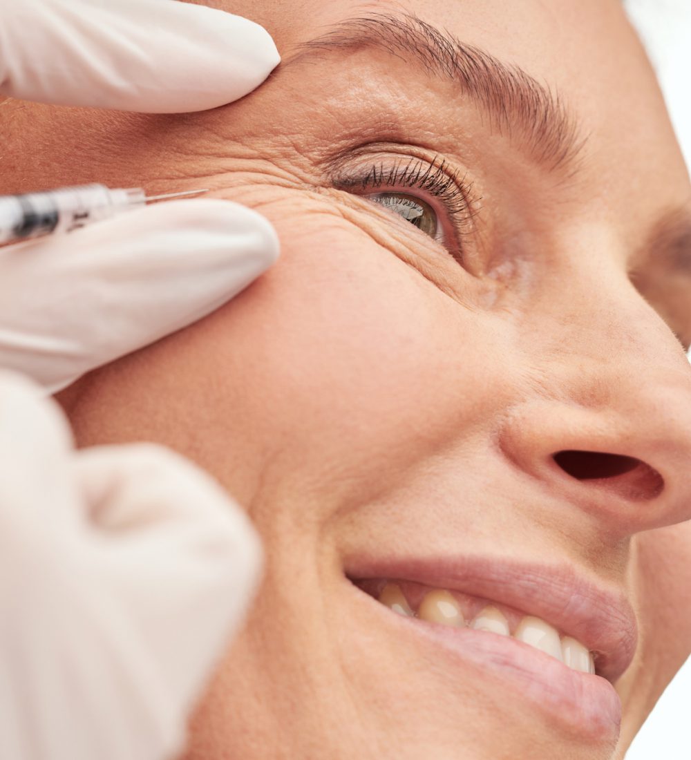 Beauty procedure. Close up of a beautiful mature woman receiving hyaluronic acid injection by beautician. Skin care and cosmetology concept