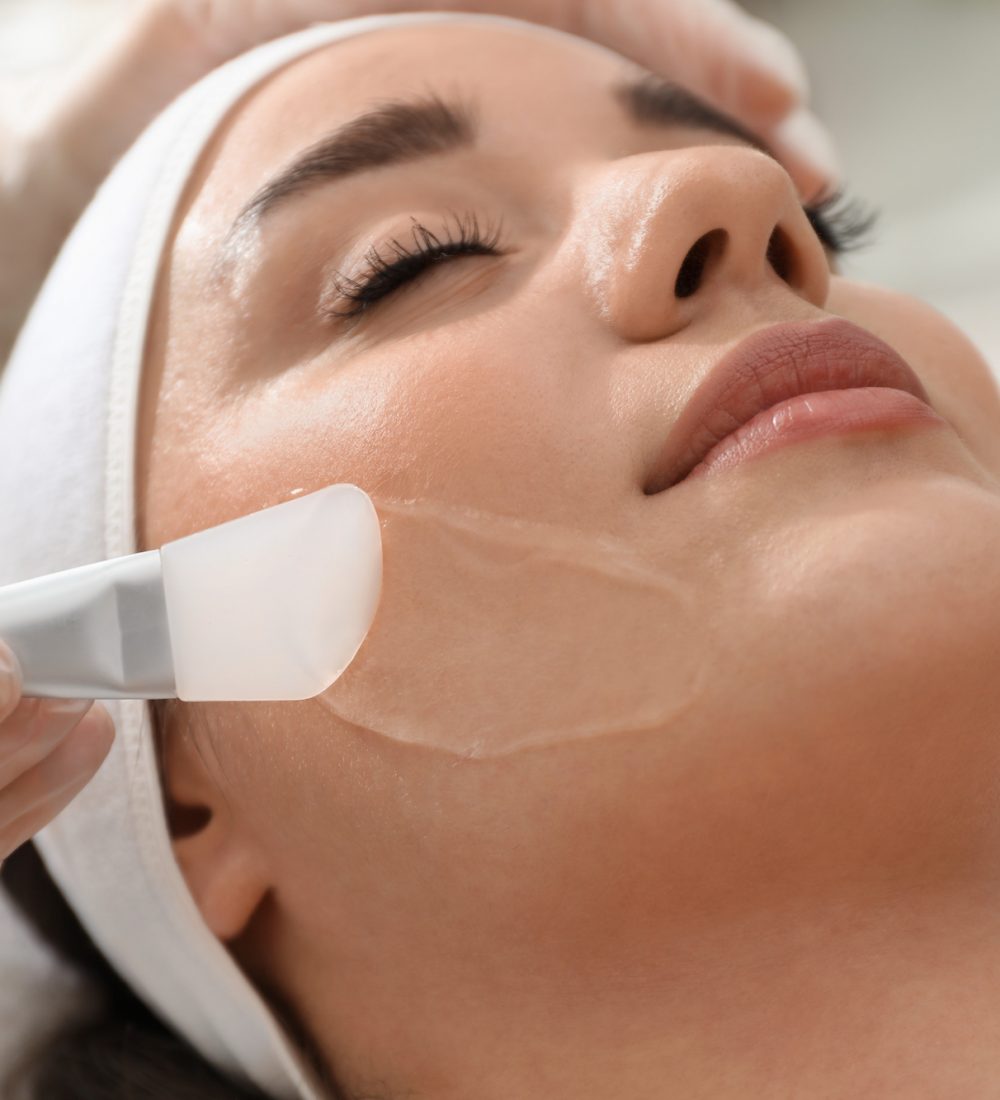 Young woman during face peeling procedure in salon, closeup